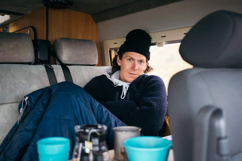 Man staying warm inside a camper.