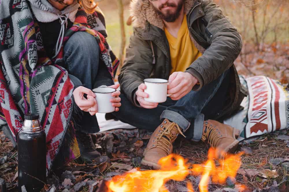 Outdoor RV camping during fall with friends around a campfire.