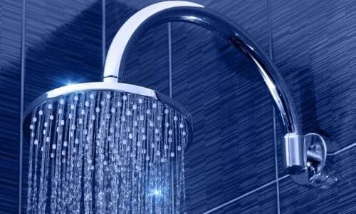 Close-up of a modern eco-friendly shower head with water flowing.