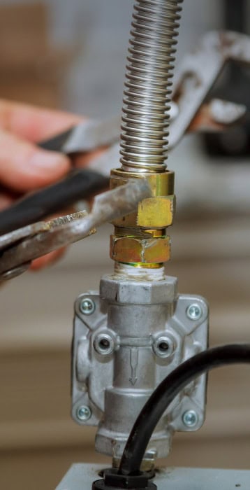 worker servicing a gas line