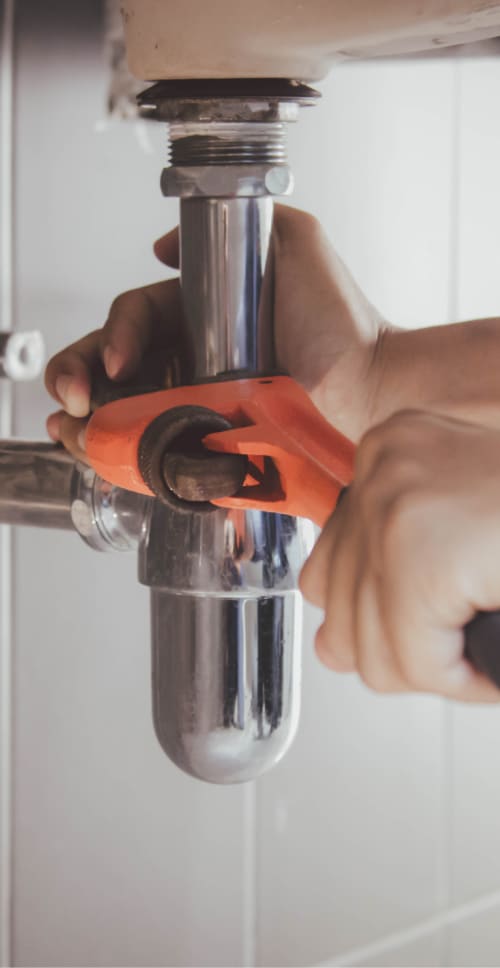 plumber working on drain in bathroom