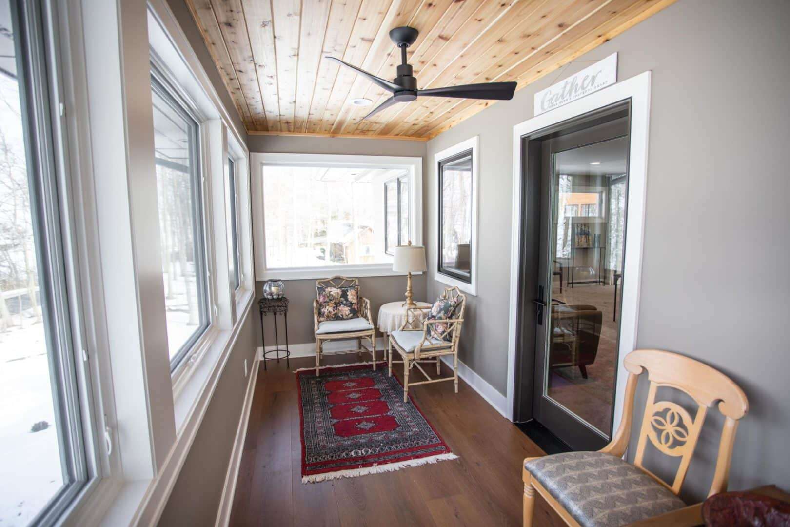Sunroom with large windows and cozy seating area.