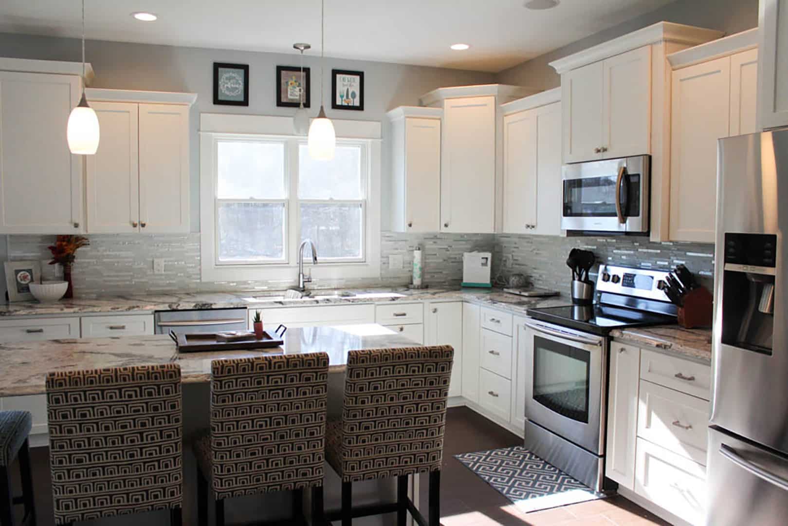 Kitchen with white cabinets, stainless steel appliances, and a bright, airy atmosphere.