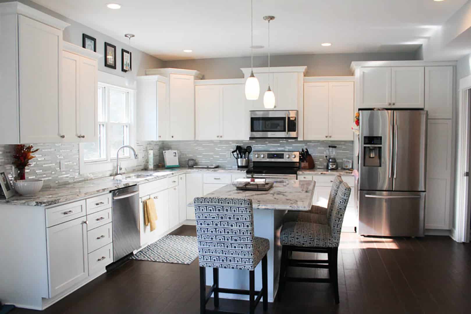 Modern white kitchen with stainless steel appliances and island.