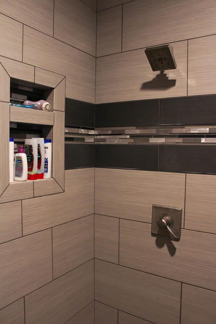 Shower with built-in niche, rainfall showerhead, and stylish tile design.