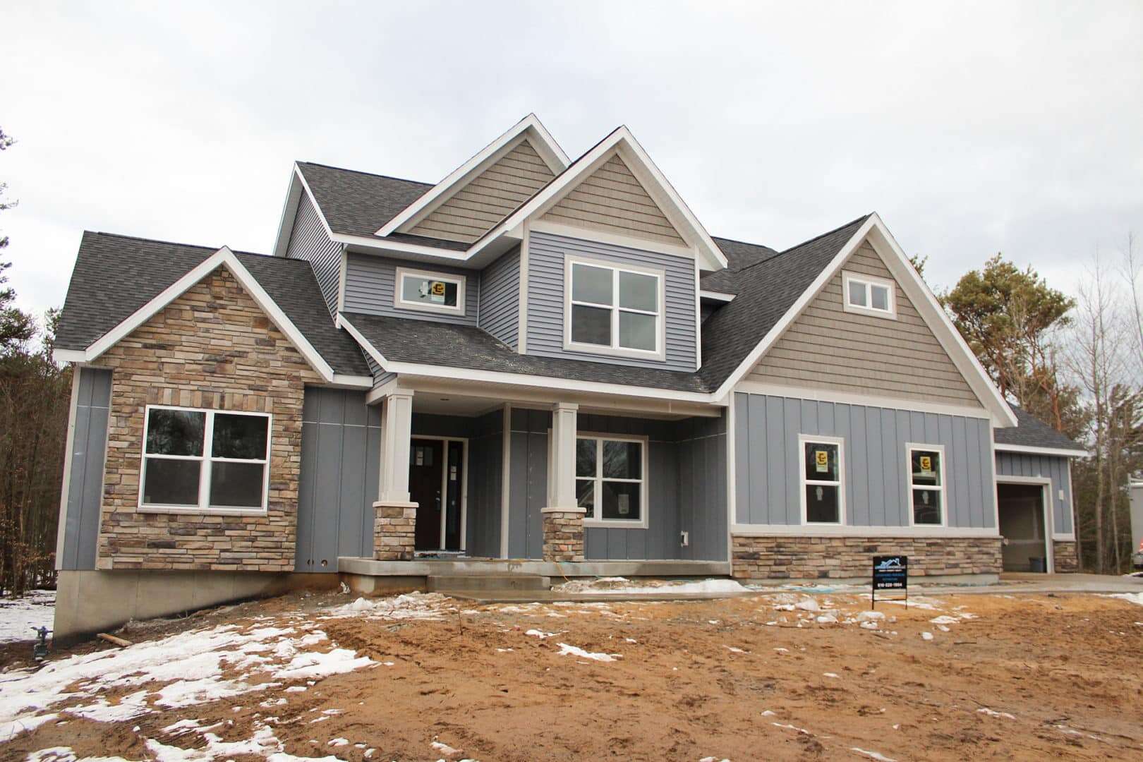 Livingston Homes new construction in progress, showcasing a blend of stone and siding exterior.