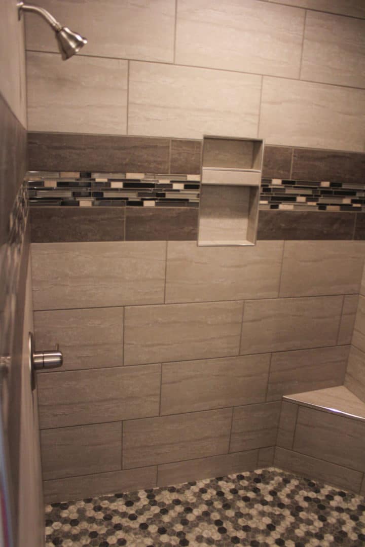 Bathroom shower featuring contemporary tile work and a stylish niche for toiletries.