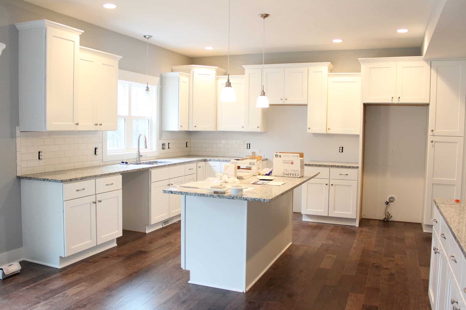 White kitchen with island, cabinetry, and modern appliances for home cooking and entertaining.