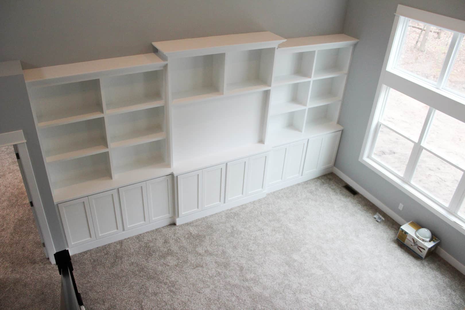 Custom built-in white shelving unit in a modern living room.