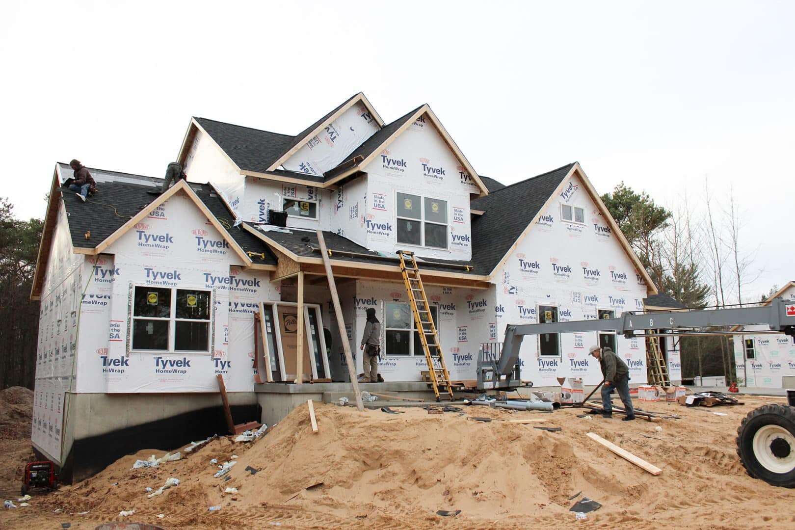 New residential home under construction with framing and workers on site.