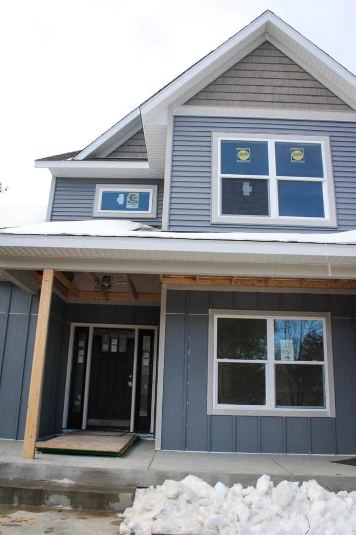 New home construction with blue siding and large windows.
