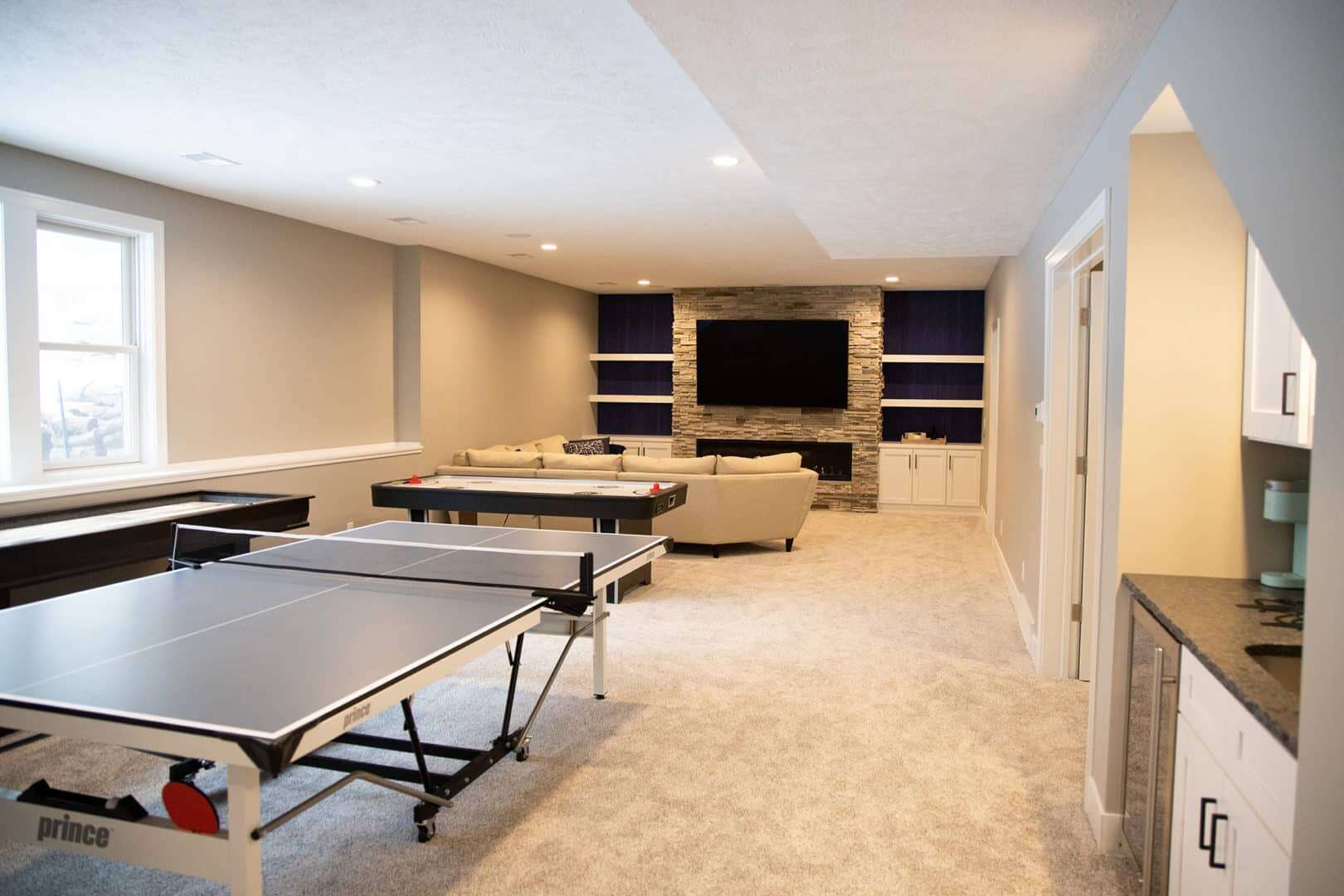 Spacious basement game room with ping pong and entertainment area. Perfect for family fun and relaxa.