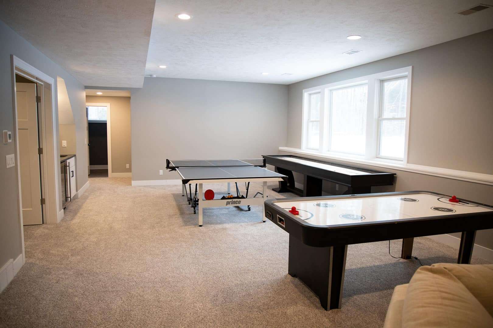 Spacious living room with ping pong and air hockey tables, perfect for family entertainment and rela.
