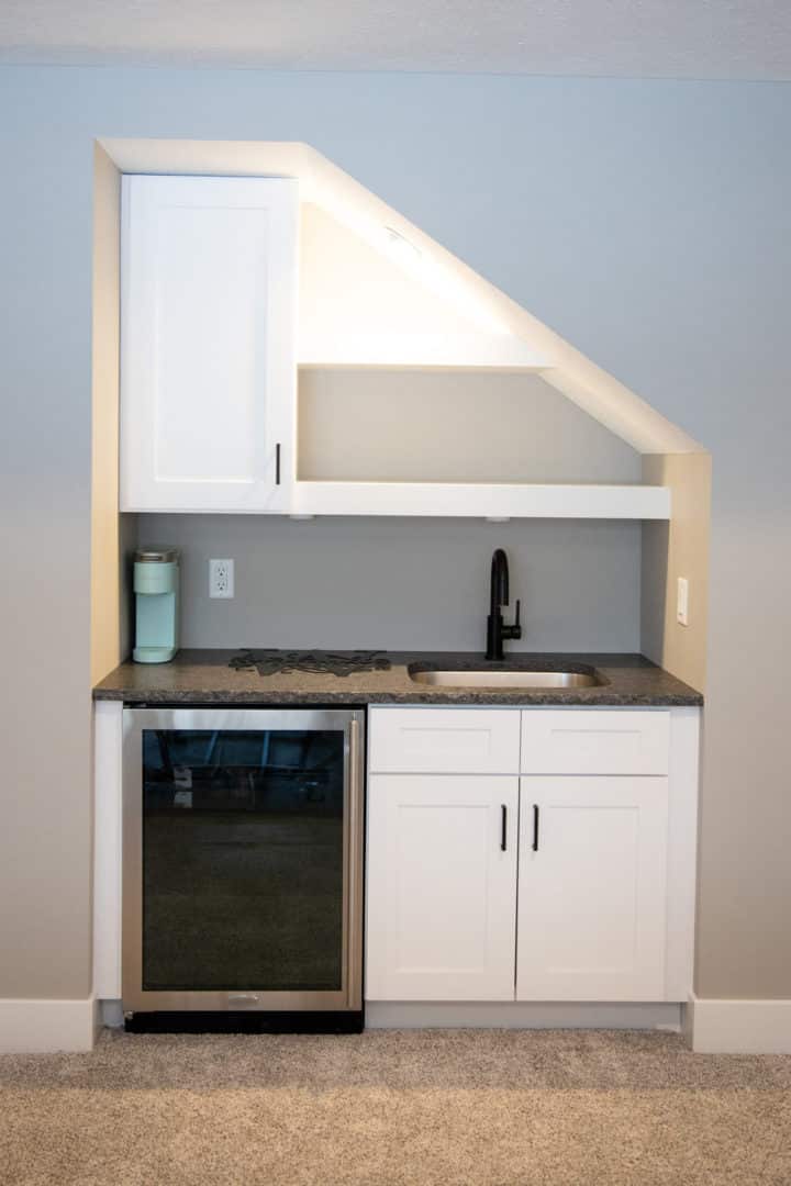 Modern compact kitchen with white cabinets and black sink in Livingston Homes.