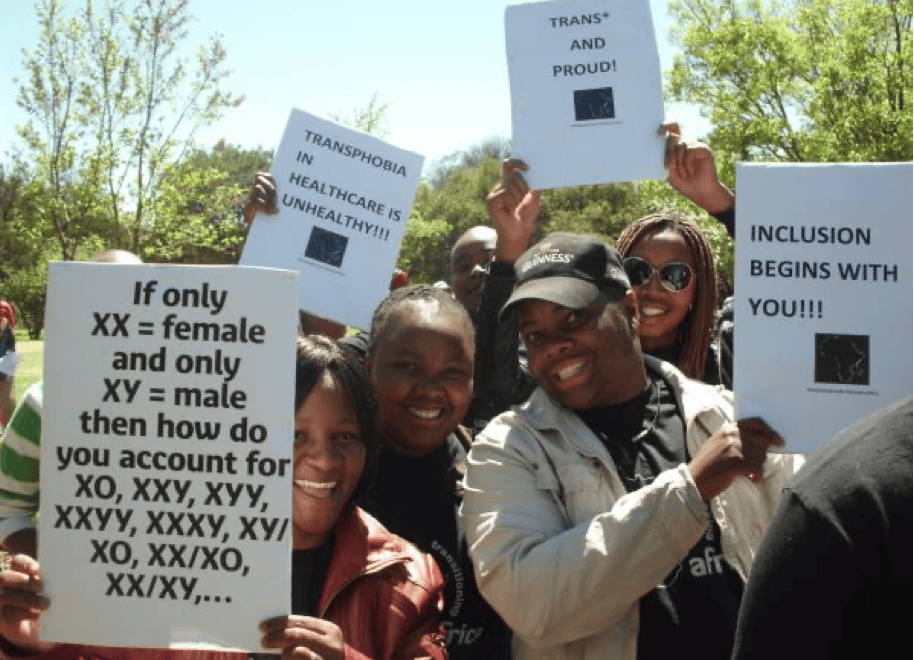 Members of Transgender and Intersex Africa hold up signs saying: inclusion starts with you" and " Trans and Proud"