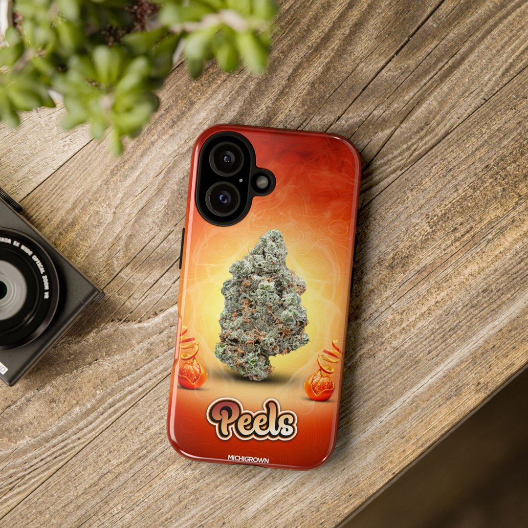 Red phone case with cannabis bud graphic and Peels logo on wooden surface.