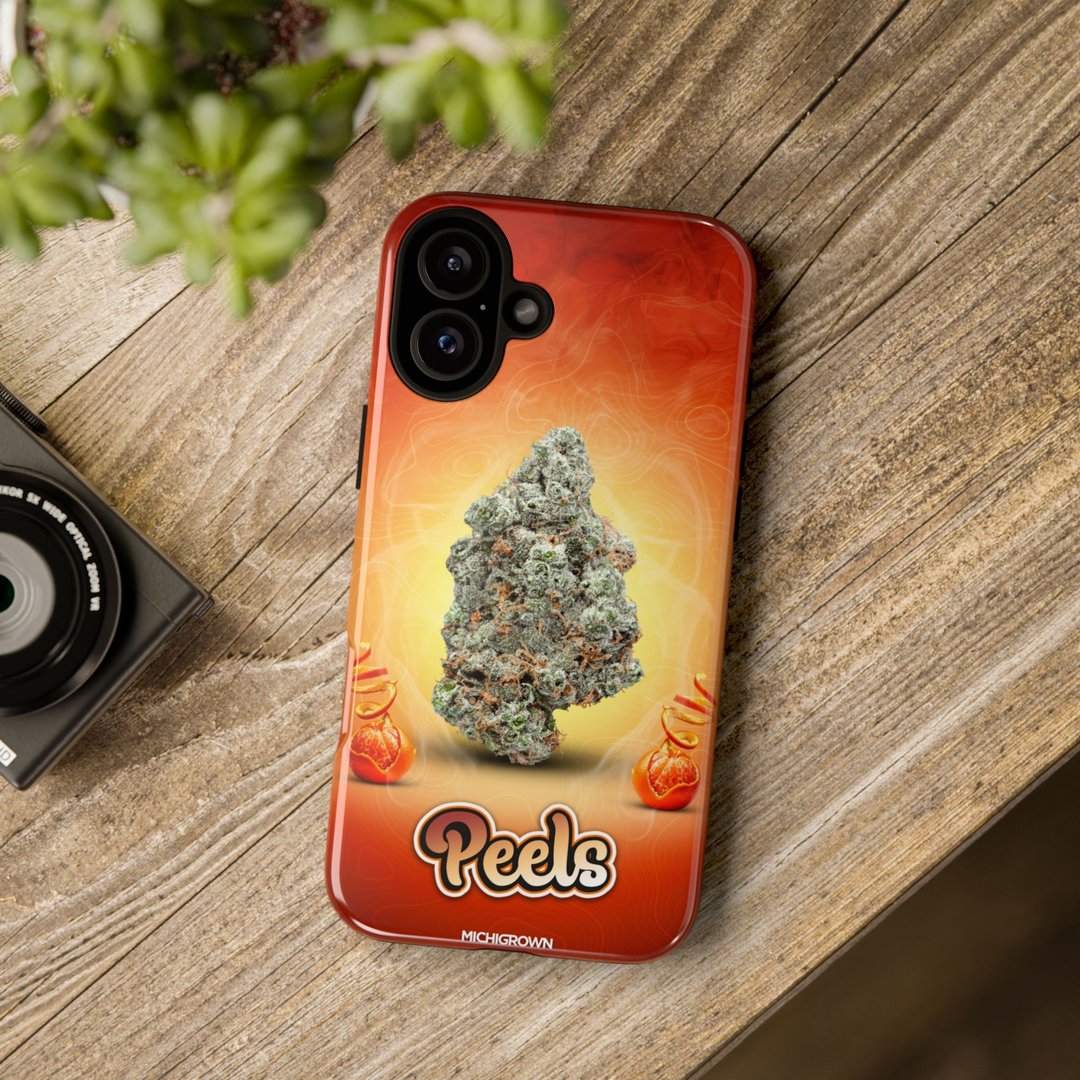 Phone case featuring cannabis bud and Peels logo on wooden surface.