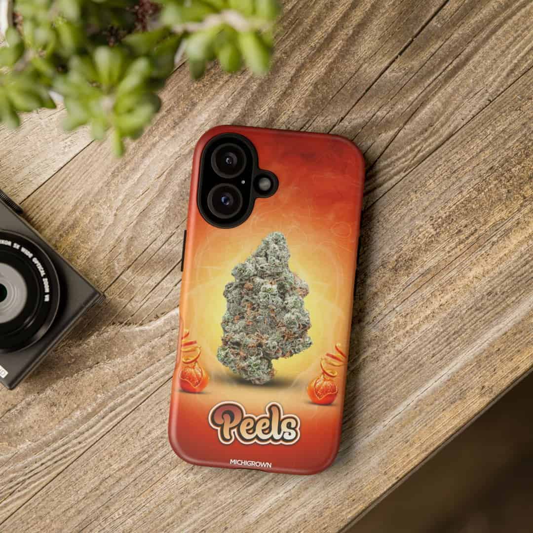 Phone case featuring cannabis bud and Peels logo on wooden surface.