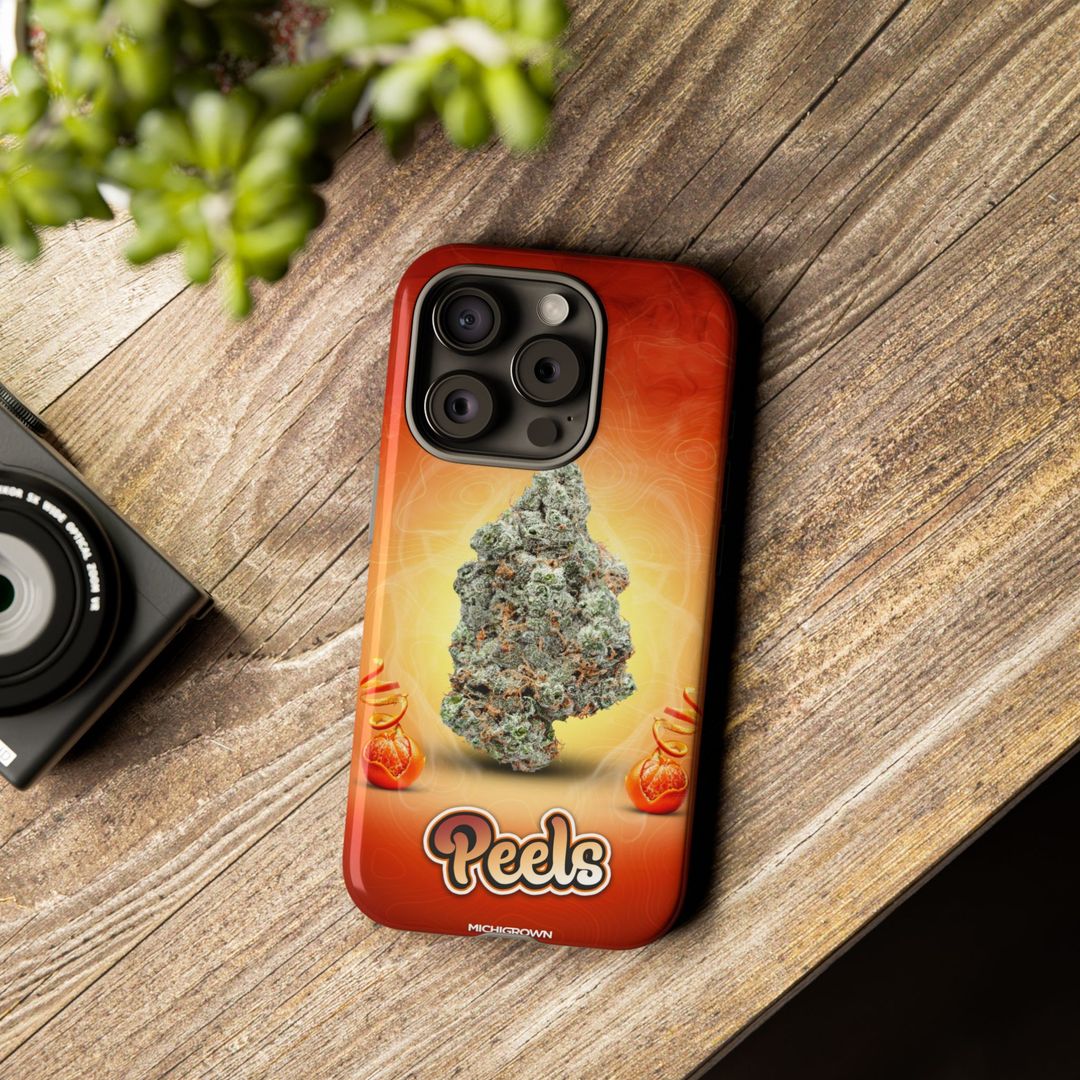 Red PEELS phone case featuring a cannabis leaf design on a wooden surface.