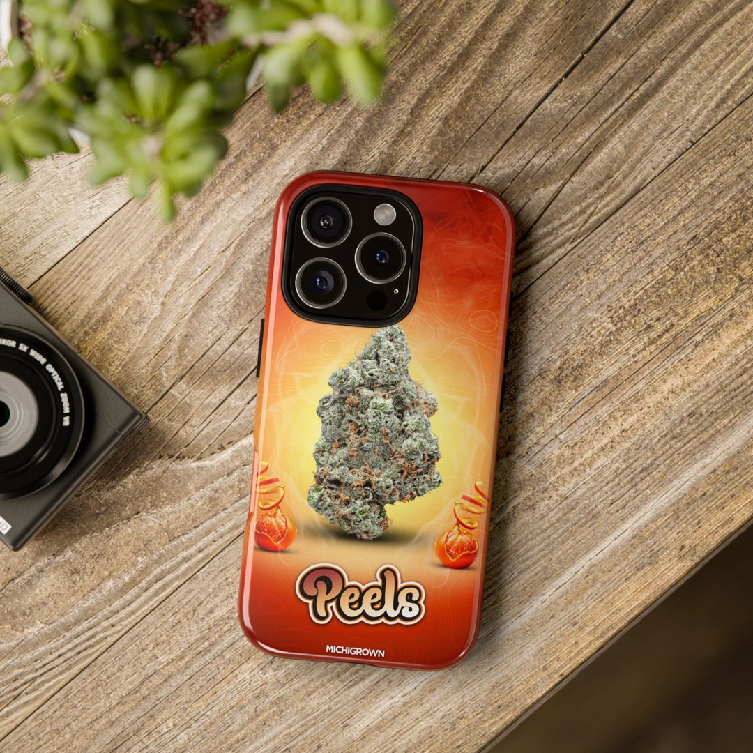 Phone case with cannabis bud design and Peels logo on wooden surface.