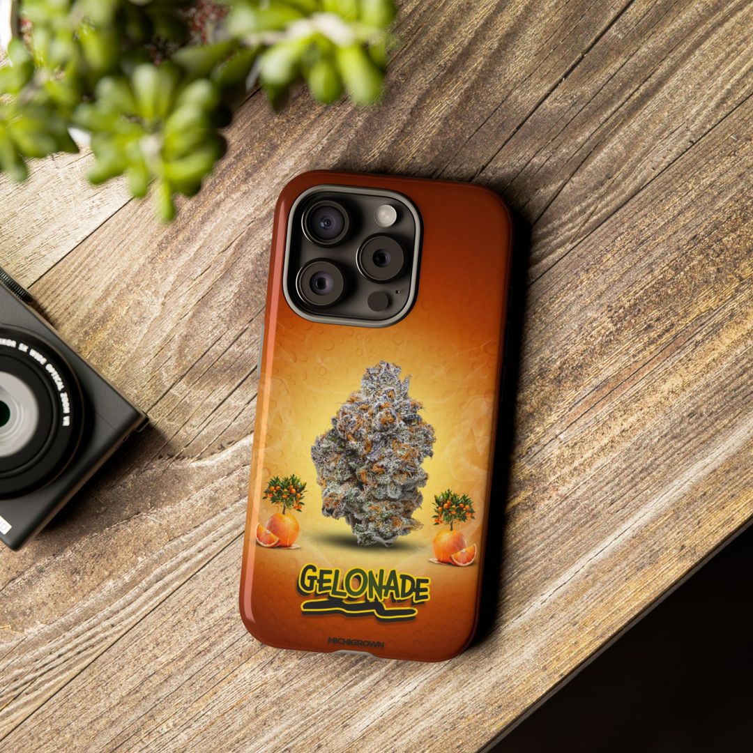 Phone case featuring cannabis bud and orange graphics on wooden surface.