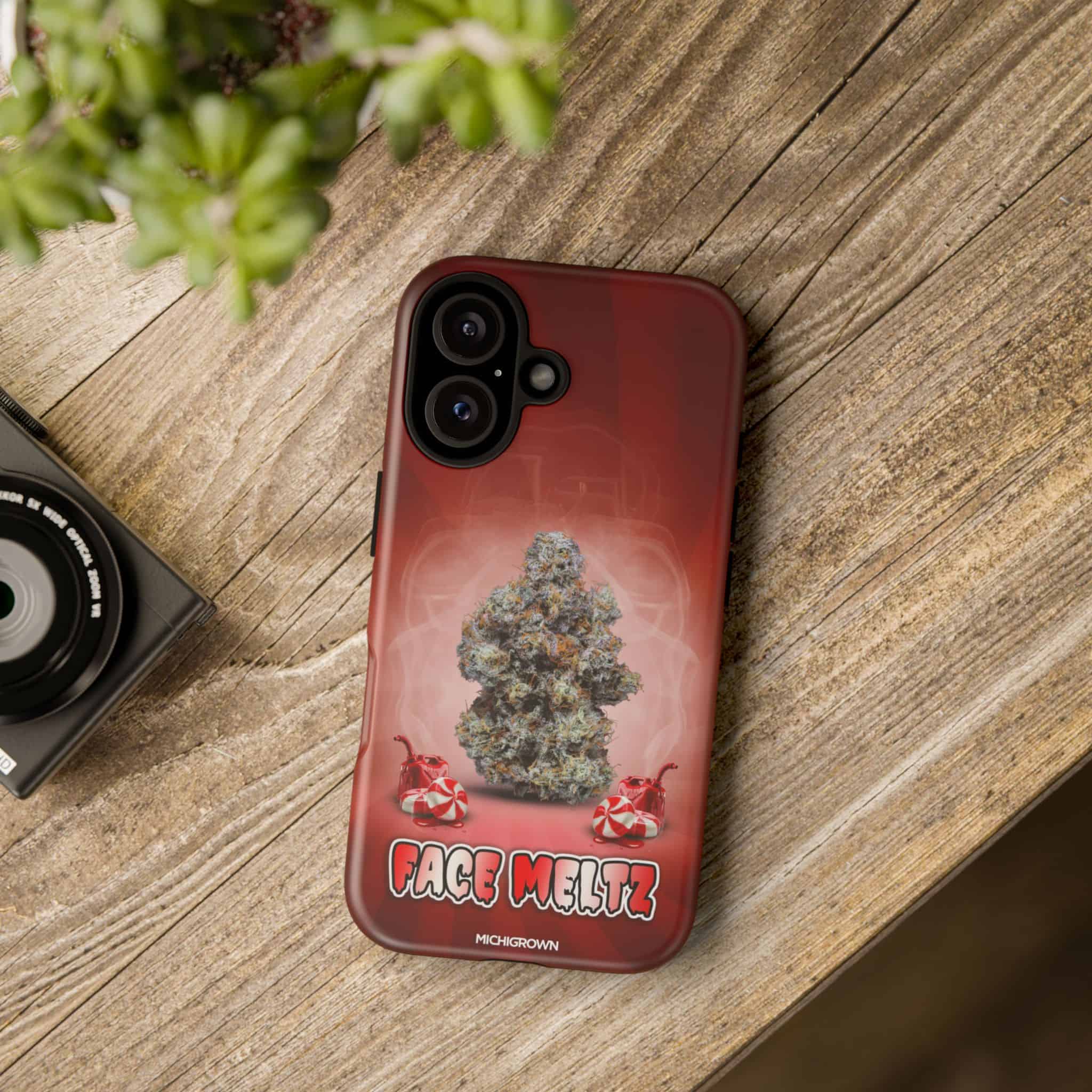 Red phone case with cannabis bud and face meltz logo for iPhone.