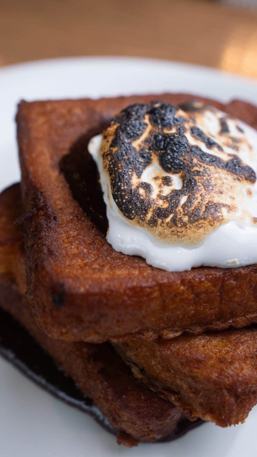 Delicious French toast topped with toasted marshmallows and whipped cream, perfect for breakfast or.
