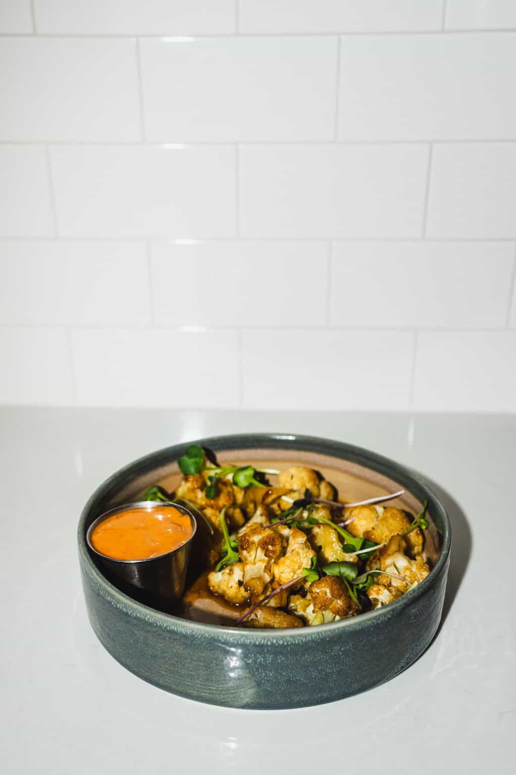 Roasted cauliflower bites served with dipping sauce.