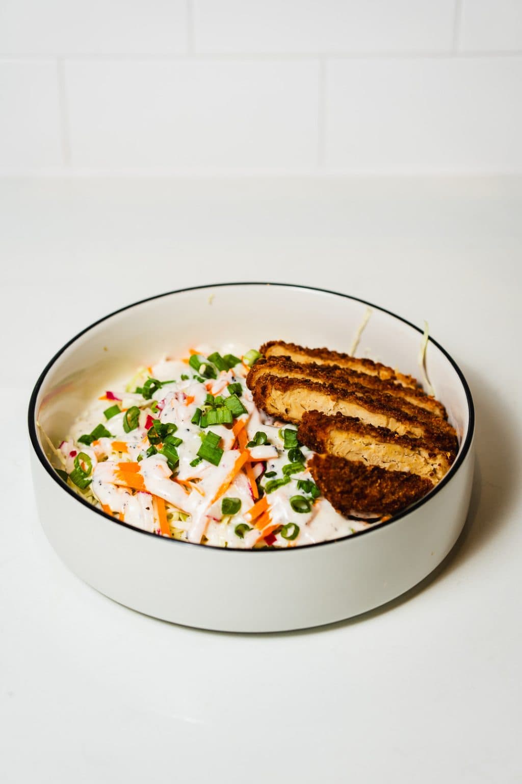 Cabbage salad with crispy plant-based chicken, scallions, radish, carrots, and creamy sesame dressing.