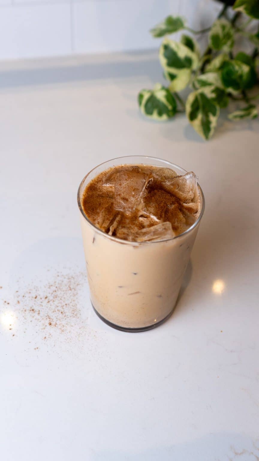 Refreshing iced coffee drink topped with ice cubes in a transparent glass.