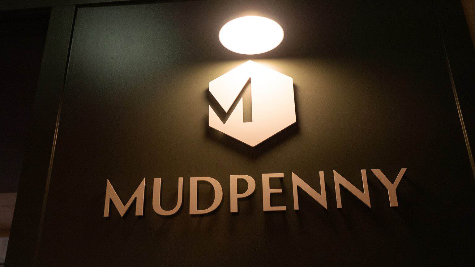Mudpenny logo illuminated for private event space.