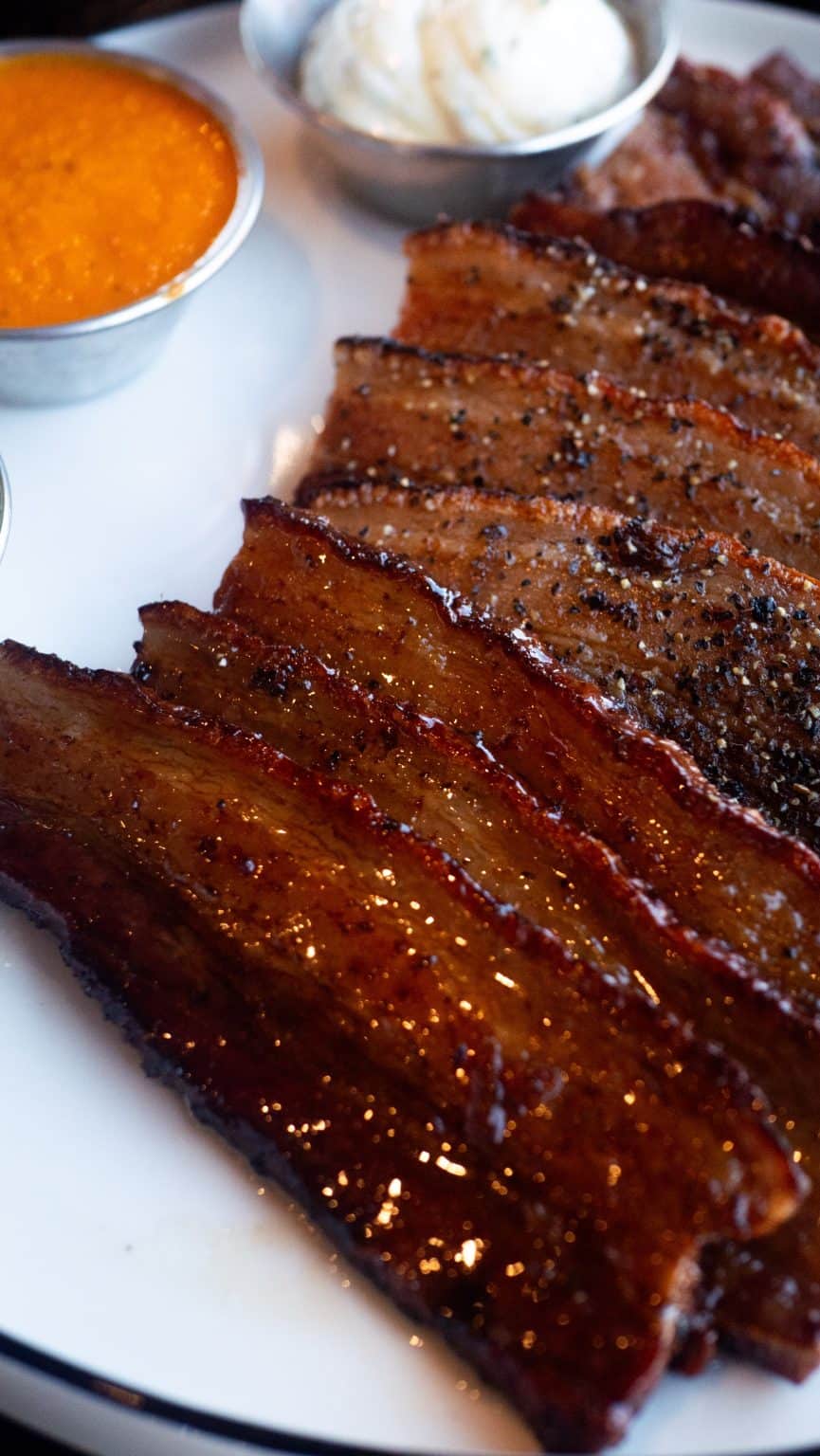 Juicy smoked ribs with barbecue sauce, served with sides and dipping sauces.