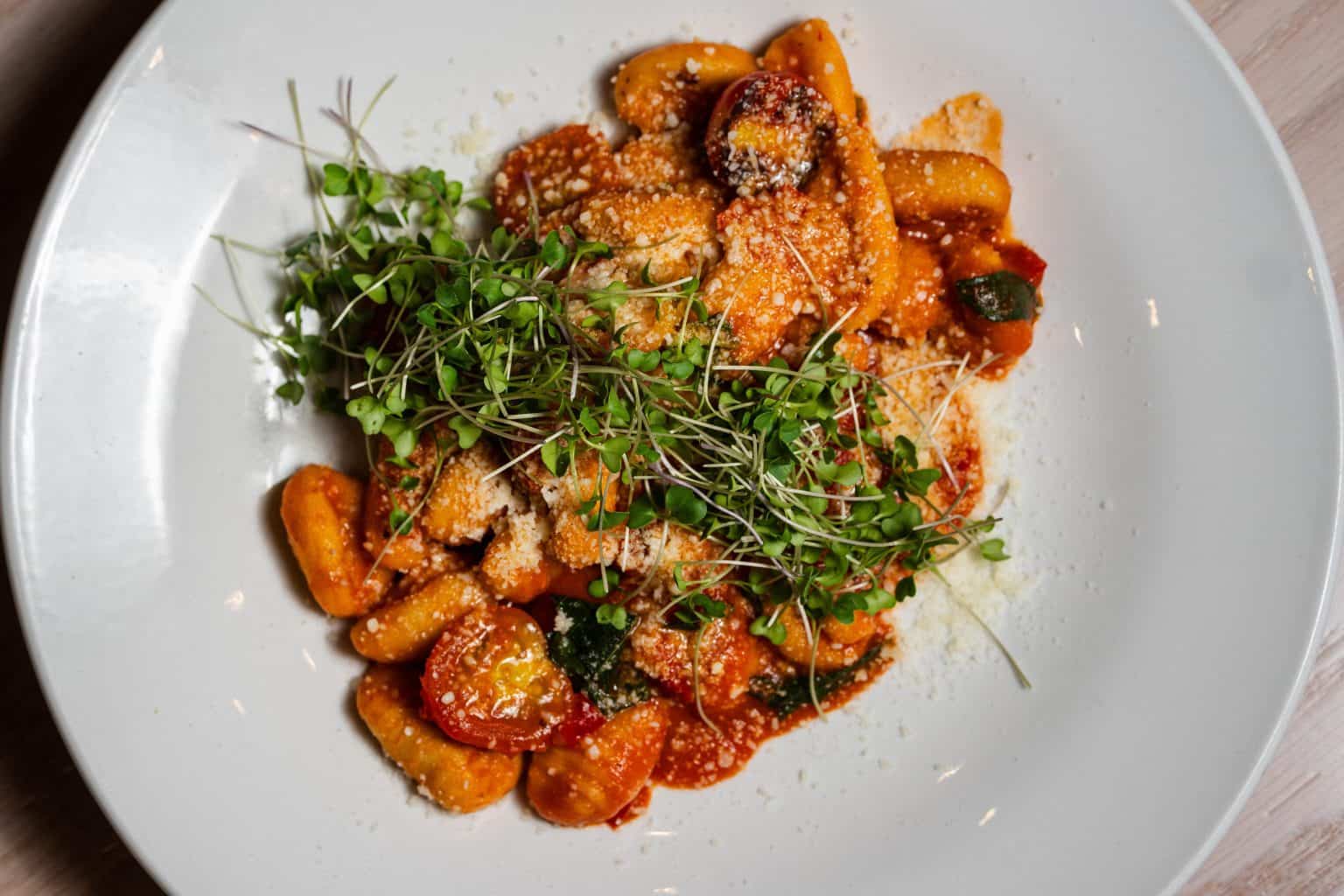 Delicious summer gnocchi dish with fresh herbs and tomato sauce.