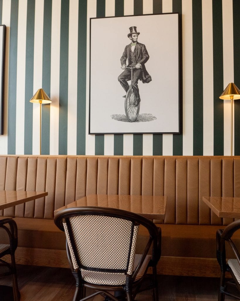 Vintage man riding a unicycle artwork in a stylish cafe interior.