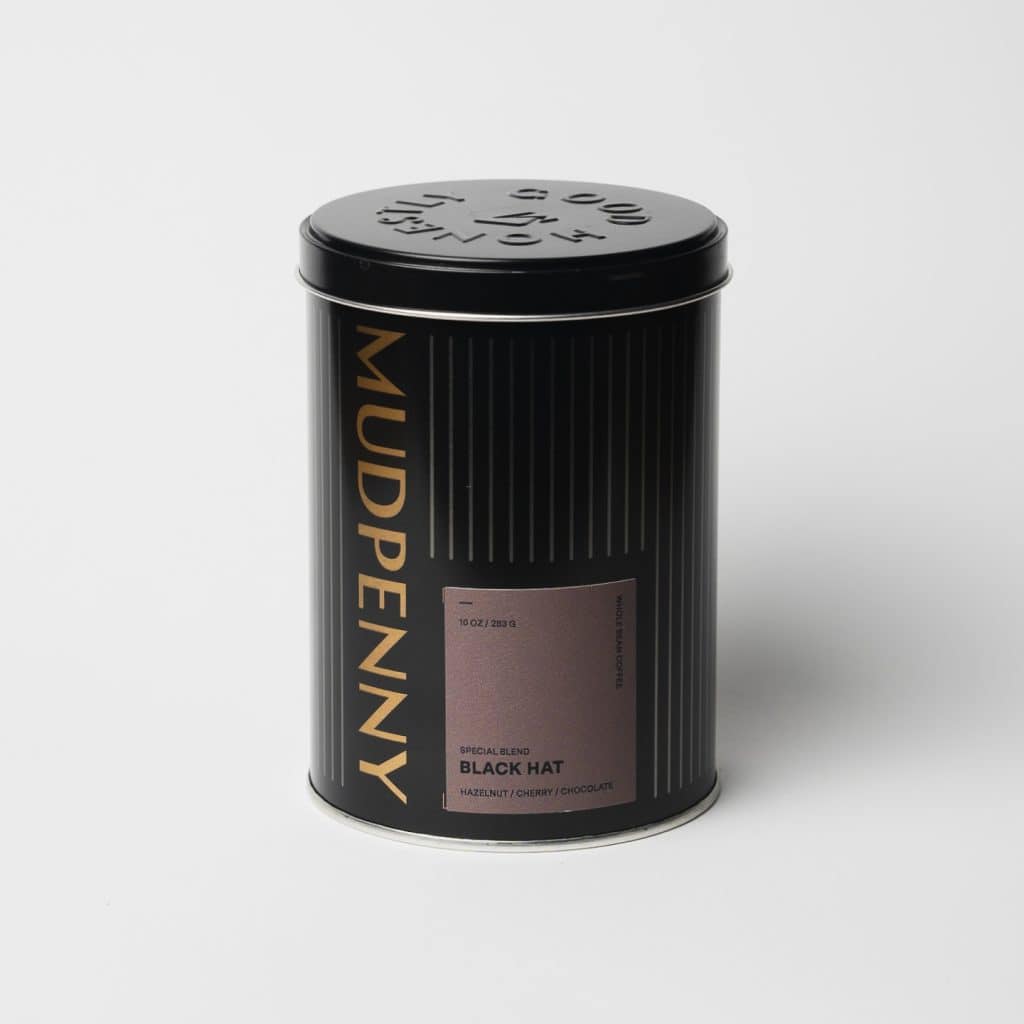 Mudpenny decaf coffee tin with black hat blend label.