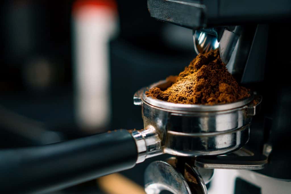 Ground whole bean coffee for espresso in a portafilter.