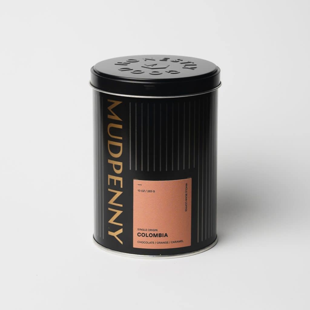 Decaf coffee tin with Mudpenny branding and Colombia origin label.
