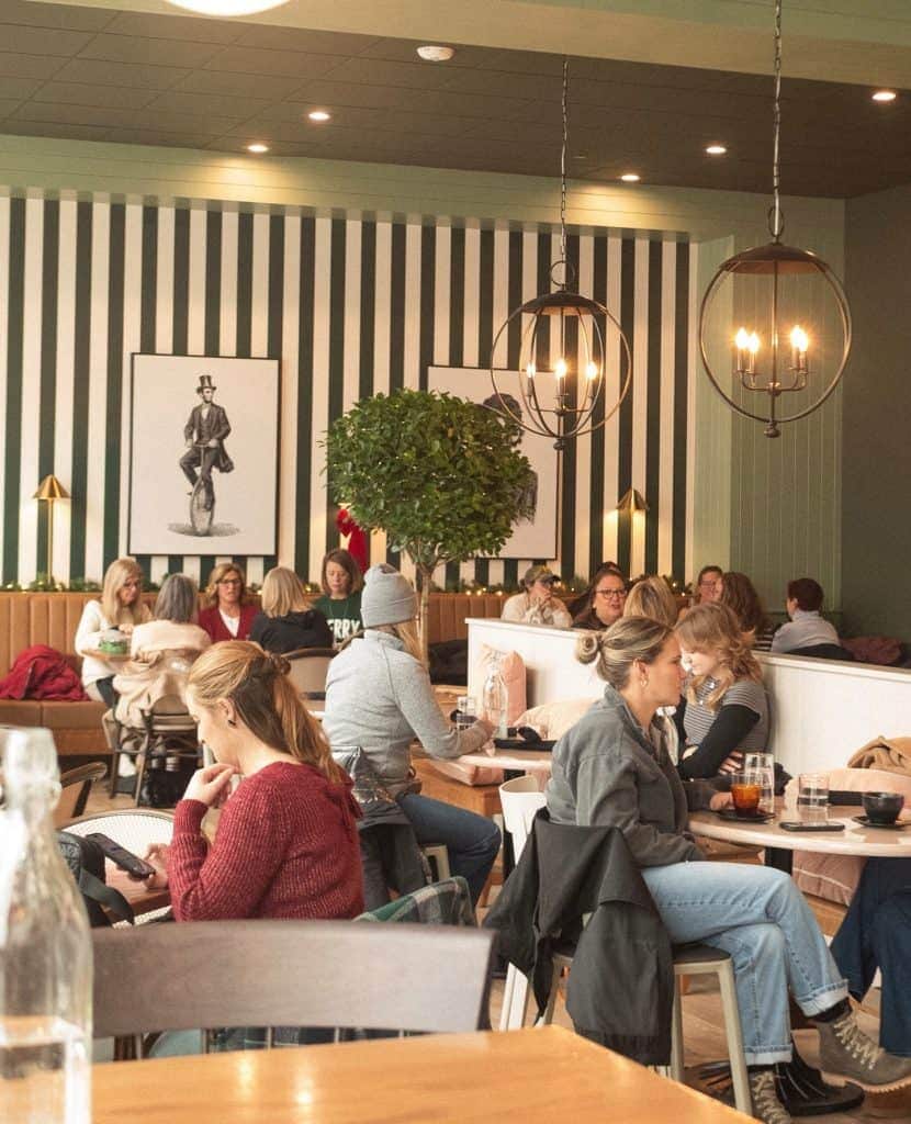 Cozy café scene featuring diverse patrons enjoying drinks and conversation inside a stylish, contemp.
