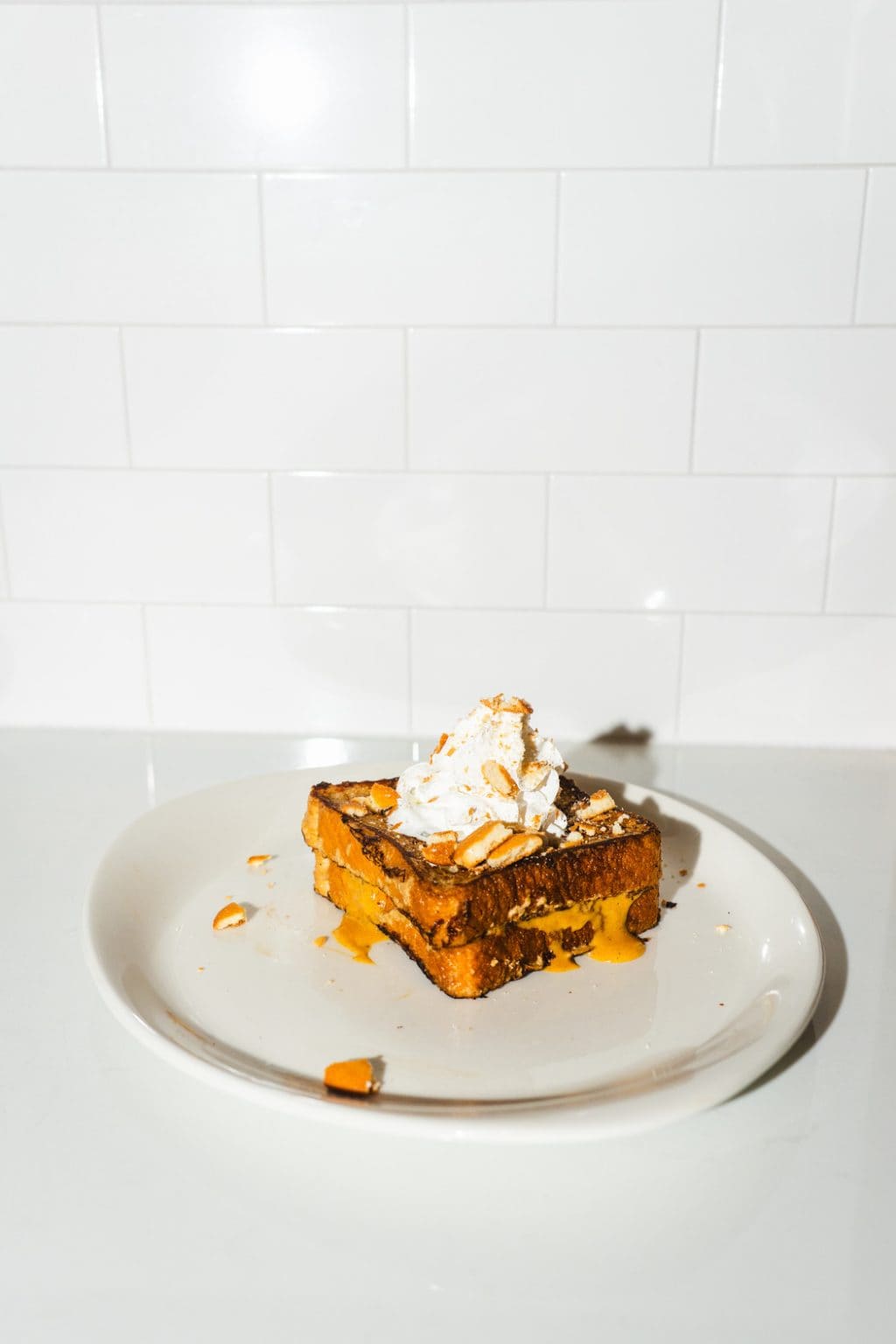 Pumpkin cheesecake French toast with whipped topping and seasonal garnish.