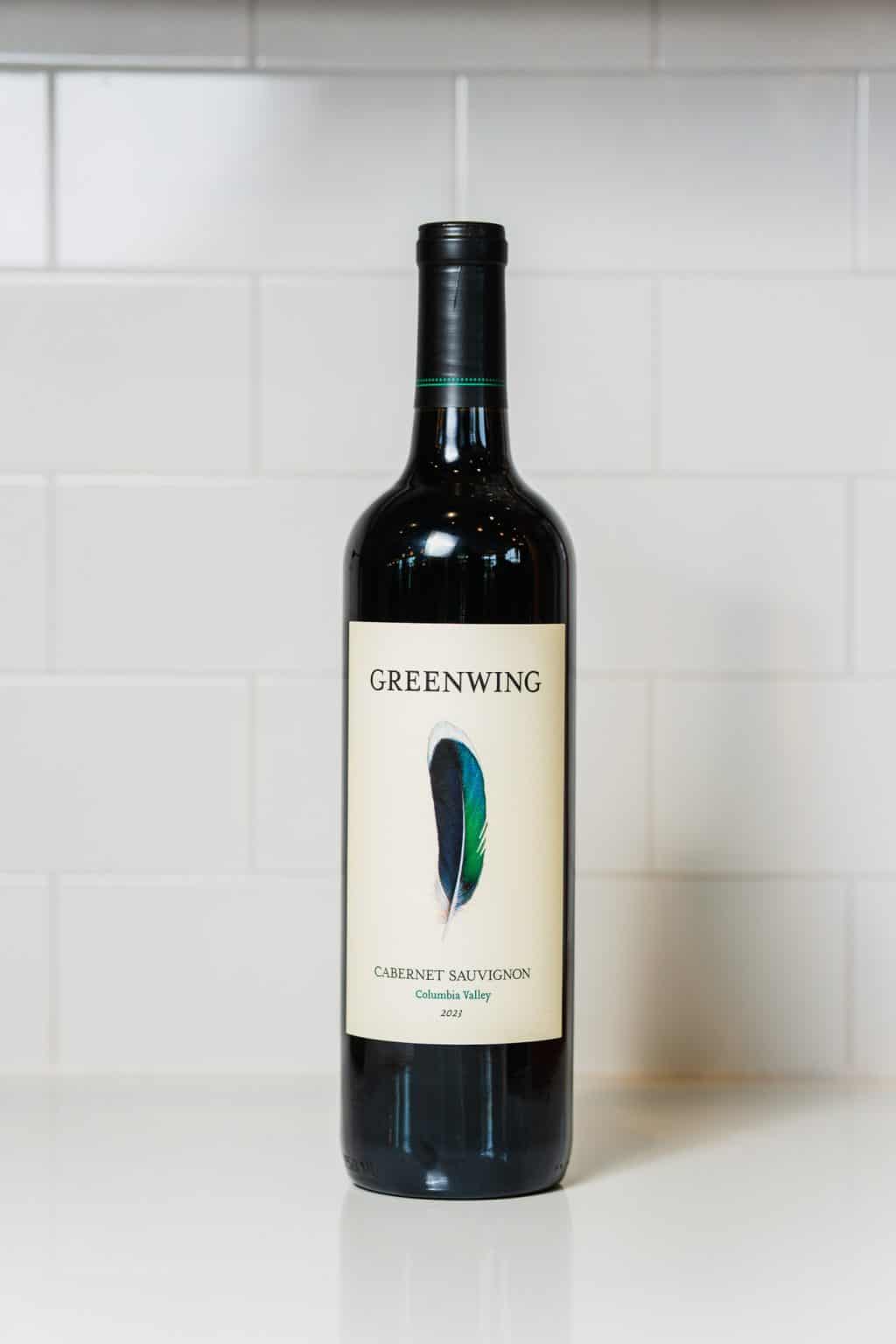Greenwing Cabernet Sauvignon wine bottle on white kitchen counter.