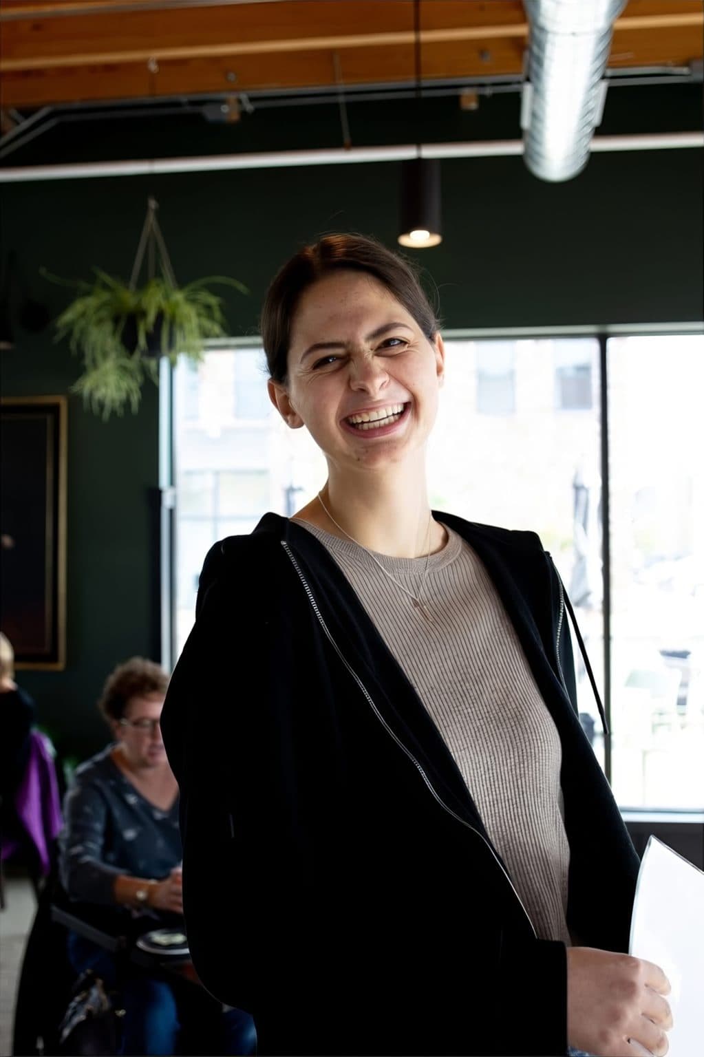Smiling woman in casual attire at Mudpenny office, showcasing a friendly work environment.