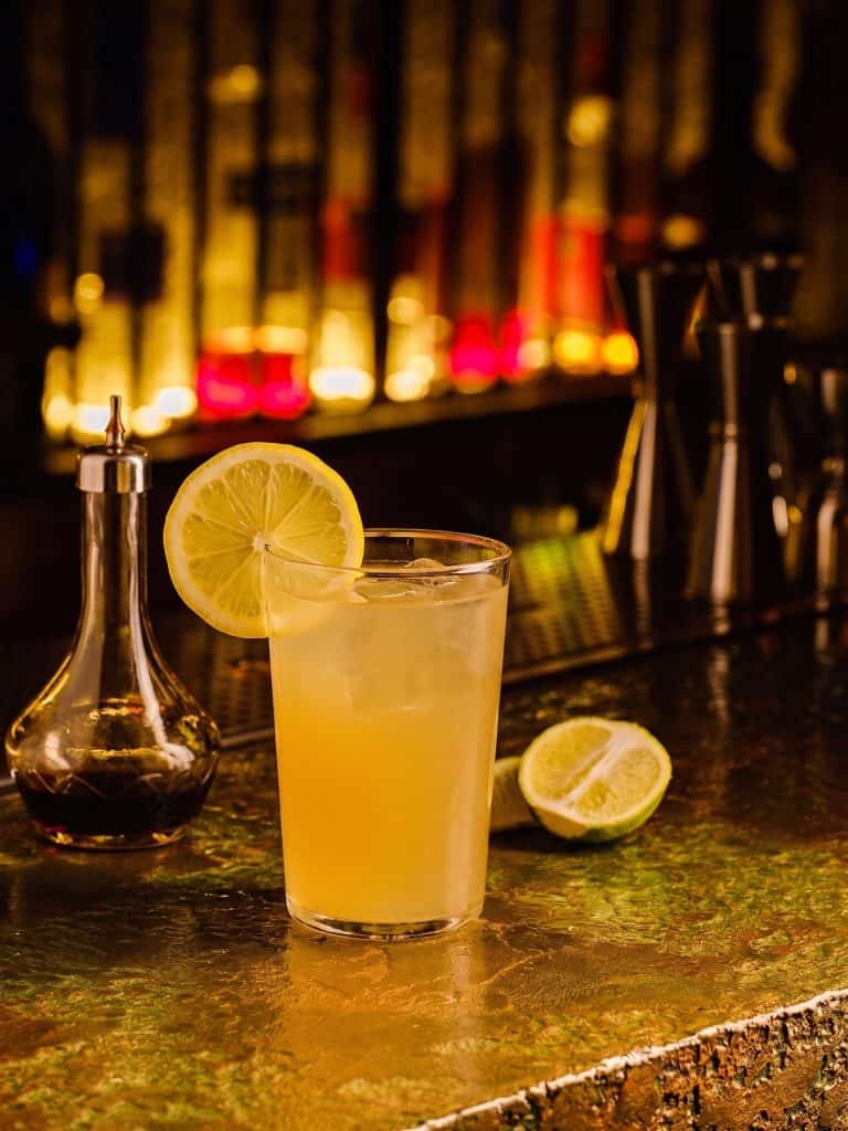 Refreshing lemonade cocktail with lemon slice at Mudpenny bar.