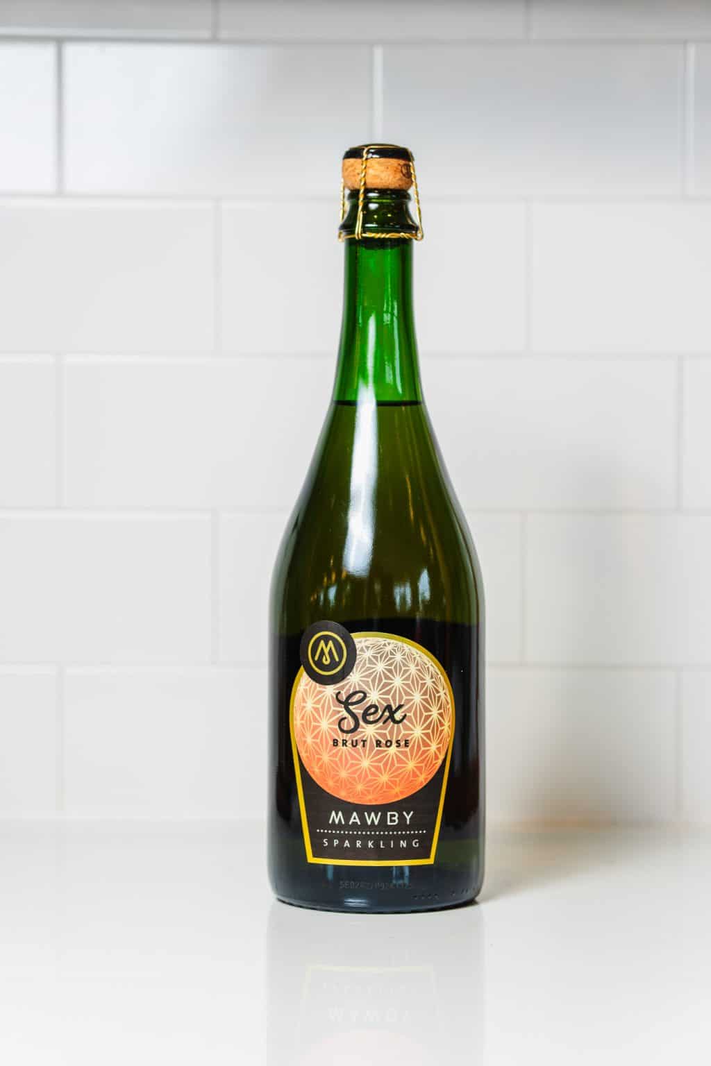 Mawby Sparkling Sex Brute Rosé wine bottle on white surface.