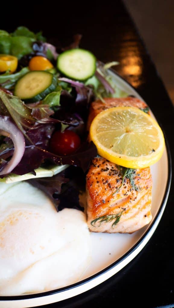 Salmon salad with lemon, cucumber, cherry tomatoes, and mixed greens.