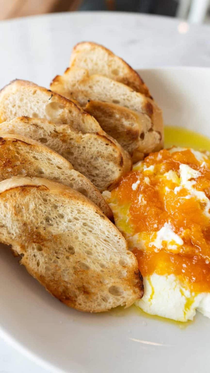 Fresh baked bread with butter and orange marmalade for breakfast or snack.