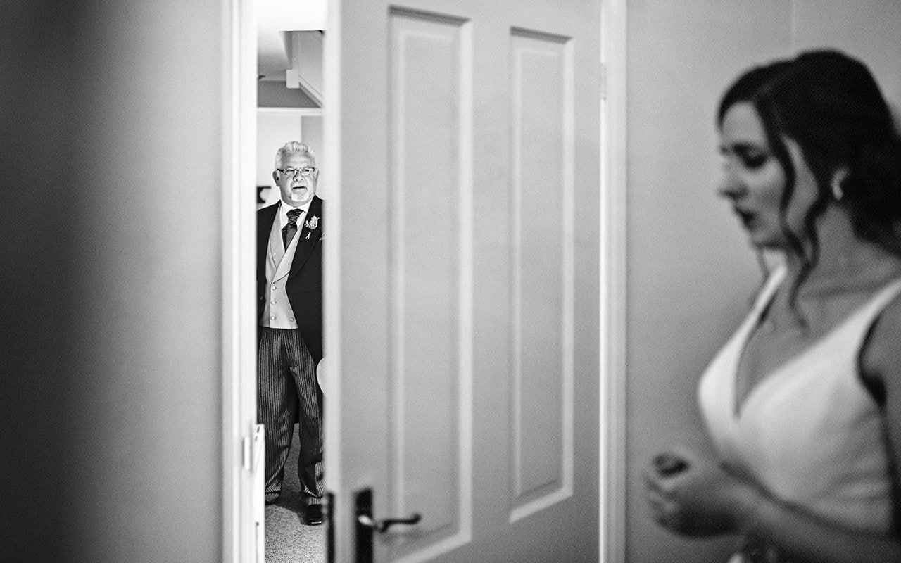 Bride waits show father her wedding dress Athelhampton House wedding morning photos dorset