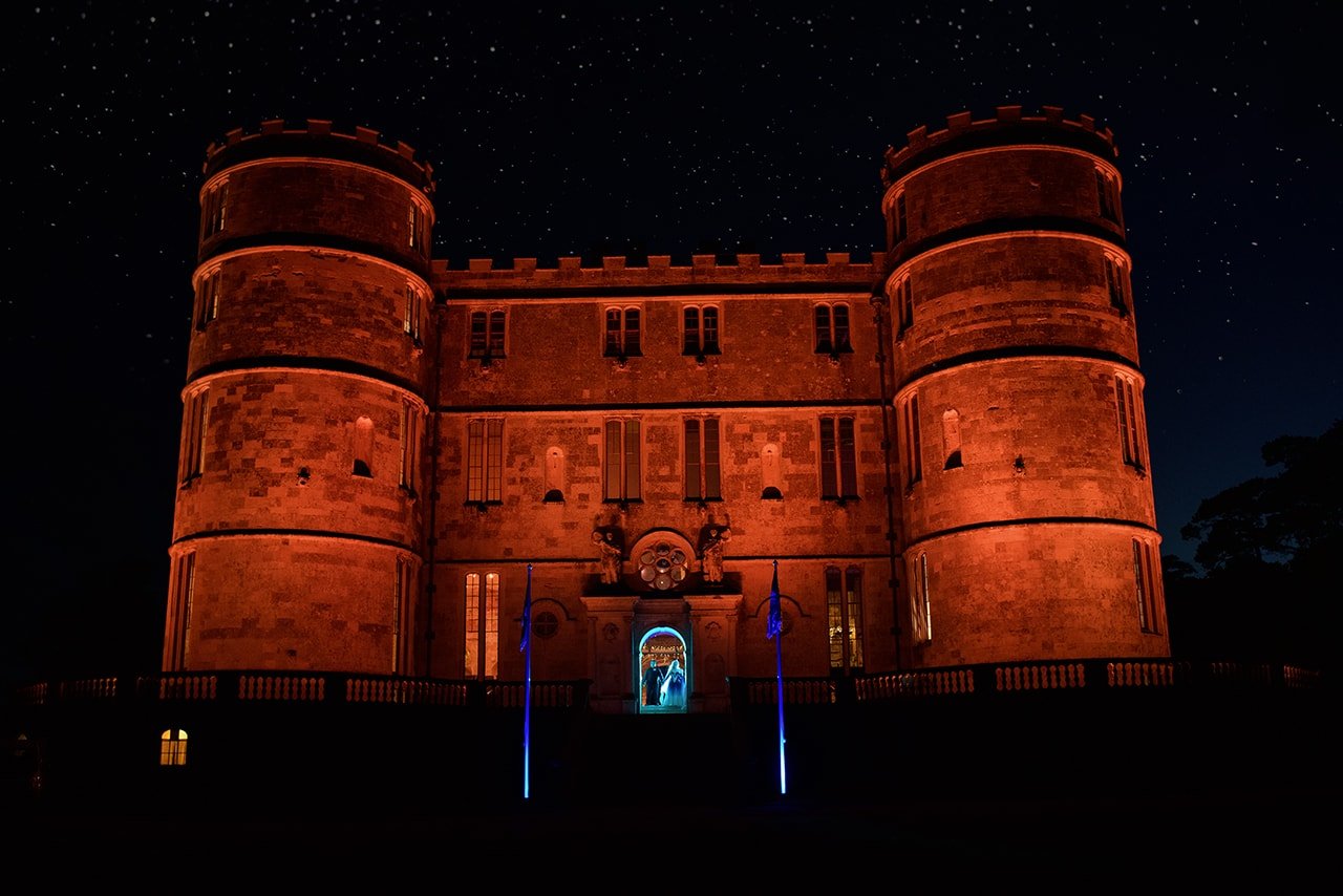 Lulworth Castle Dorset wedding venue lit orange night glowing blue bride groom couple photograph one thousand words