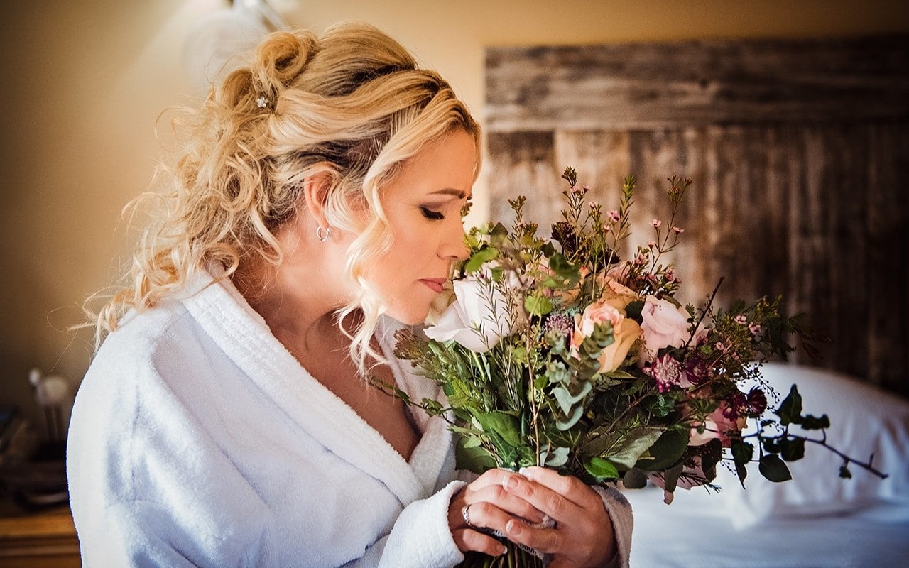 documentary wedding photograph bride smelling wedding flower bouquet New Forest wedding morning