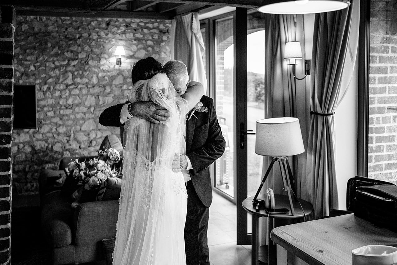 emotional wedding photo father bride hugging his daughter before Lulworth Castle wedding day
