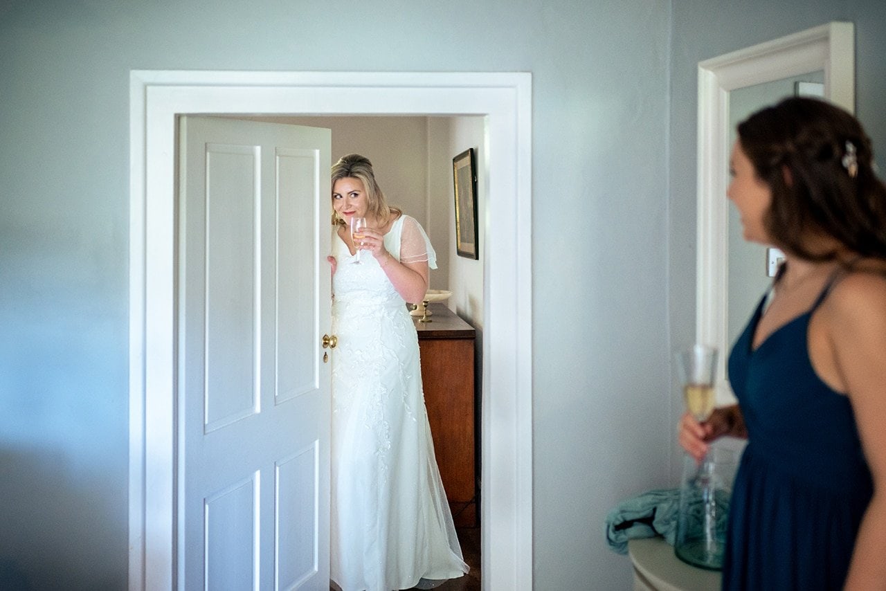 wedding morning photography example peeking bride white wedding dress Mappeton House wedding